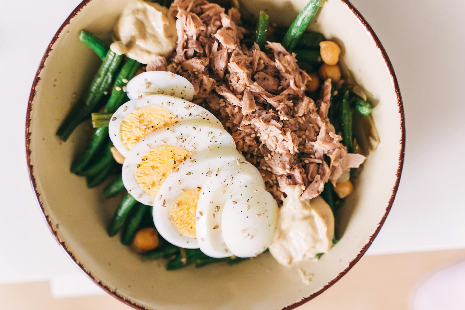 Delicious protein-packed bowl featuring tuna, boiled eggs, green beans, and hummus. - high protein low carb