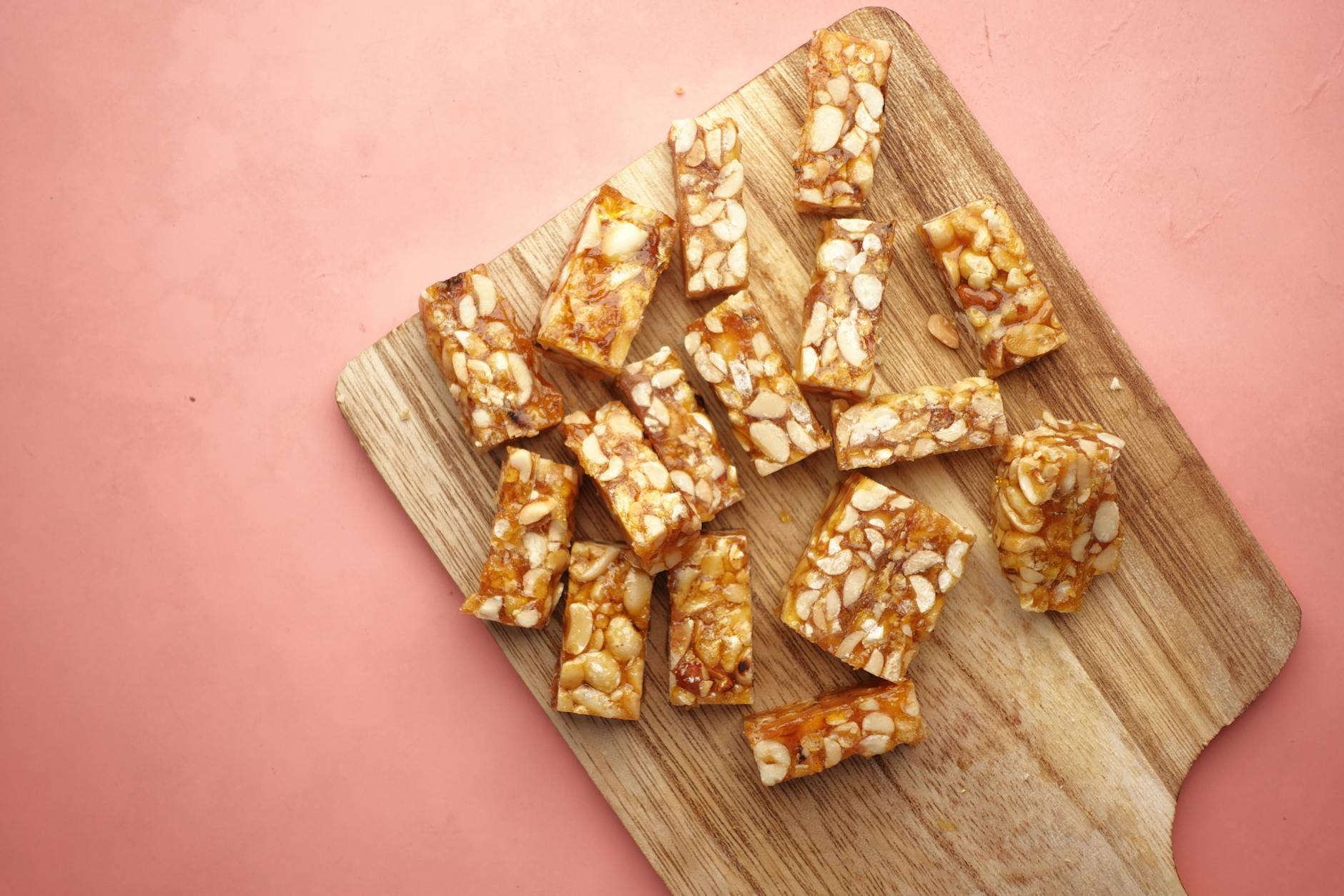 Wooden cutting board displaying tasty homemade nut bars, ready to eat. - high protein snacks