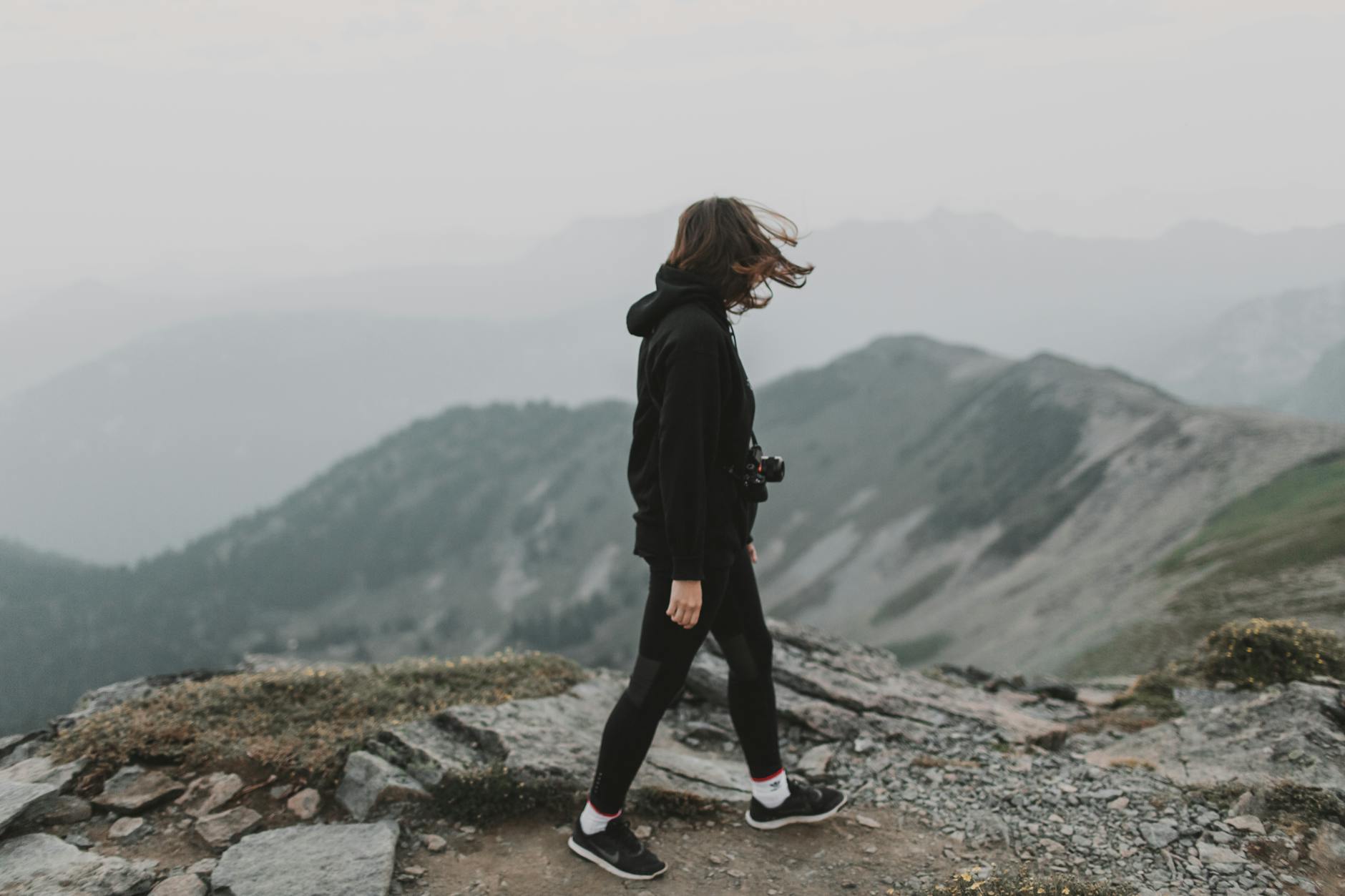 A woman in a black hoodie explores a rocky mountain path in Washington, USA. - hiking calorie burn