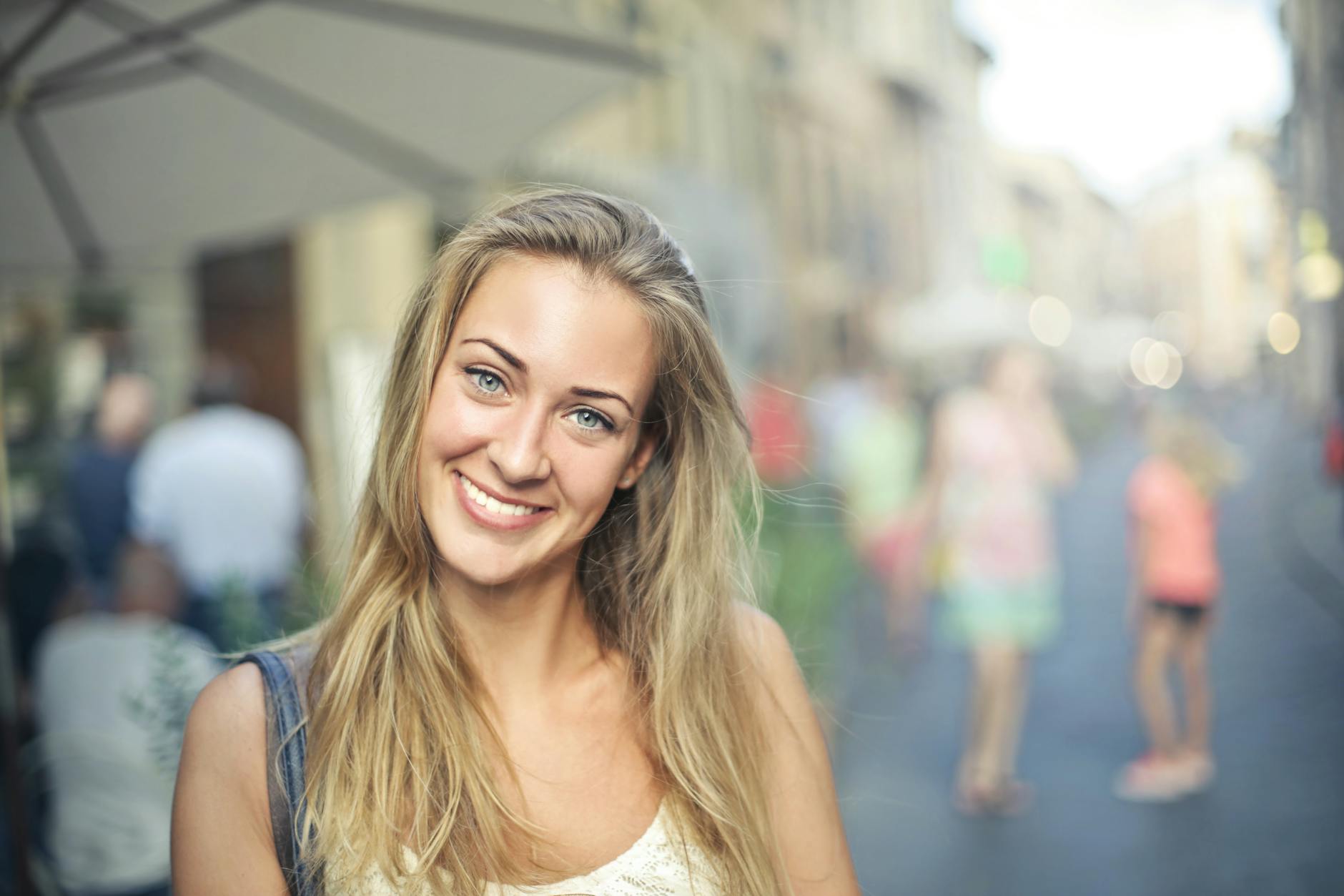 Portrait of a smiling woman with blonde hair standing outdoors in a bustling street setting. - magnesium citrate benefits