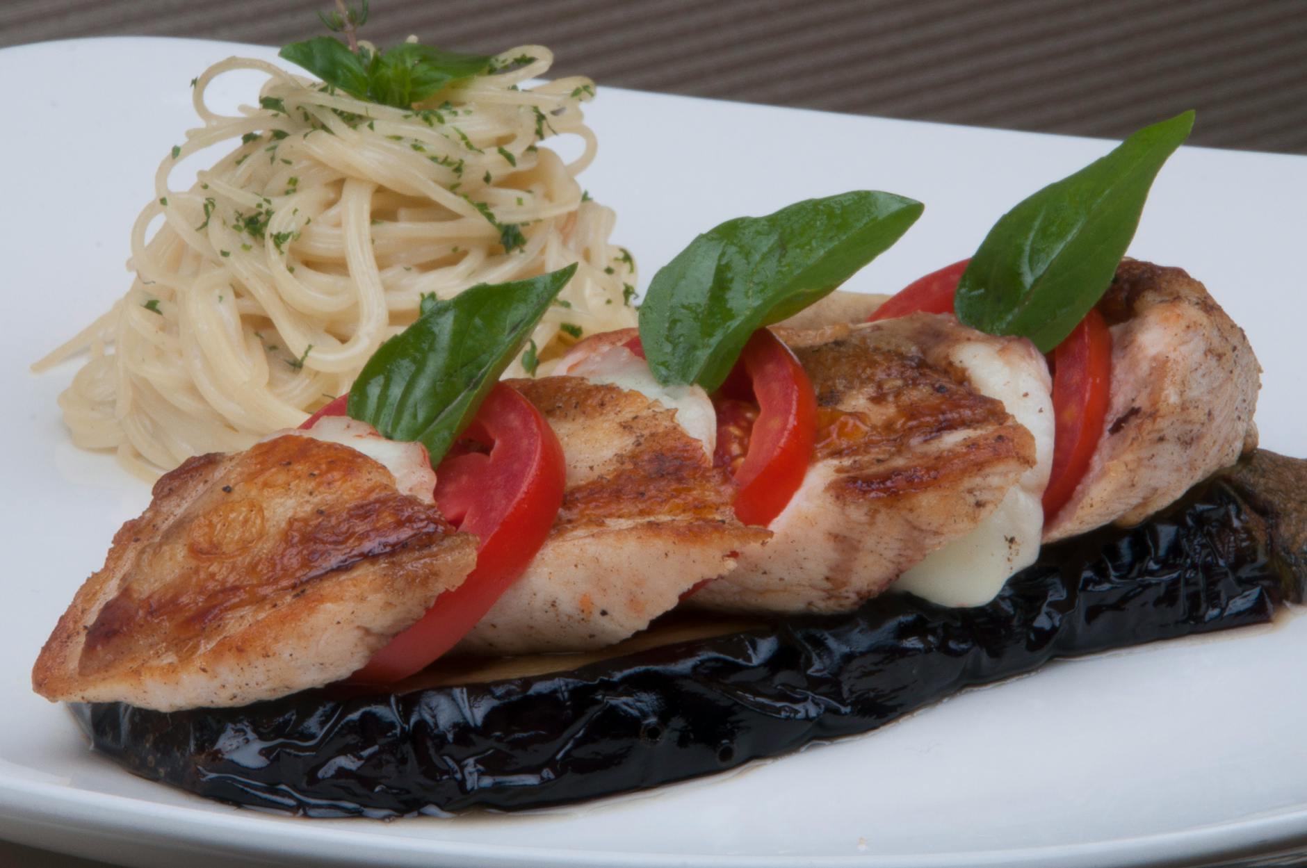 Gourmet dish featuring grilled chicken, eggplant, spaghetti, and fresh basil. - mediterranean chicken recipe