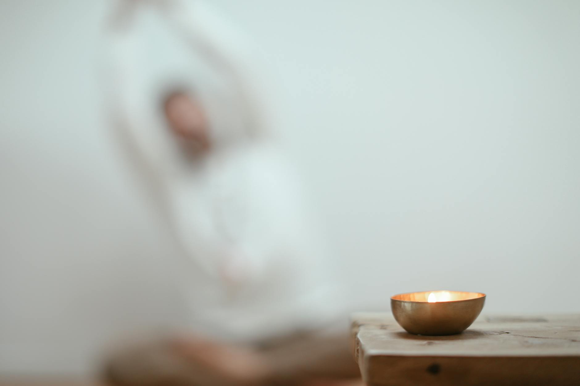 Calm scene with a singing bowl and blurred yoga pose, promoting tranquility. - mental wellness practices