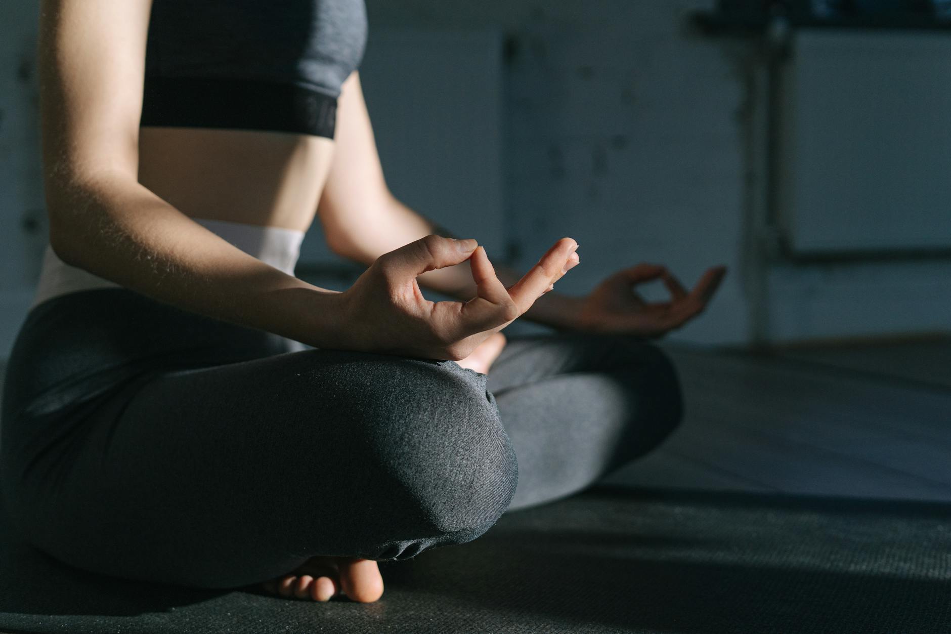 Woman practicing meditation on a yoga mat indoors, focusing on mindfulness and relaxation. - mental wellness practices