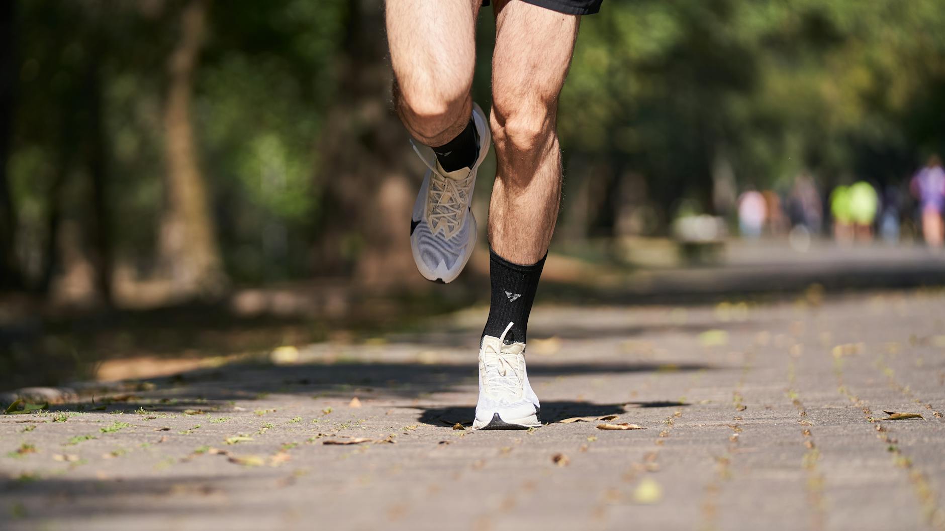 Close-up of a runner's legs in motion on a forest path, embodying speed and fitness. - morning muscle activation
