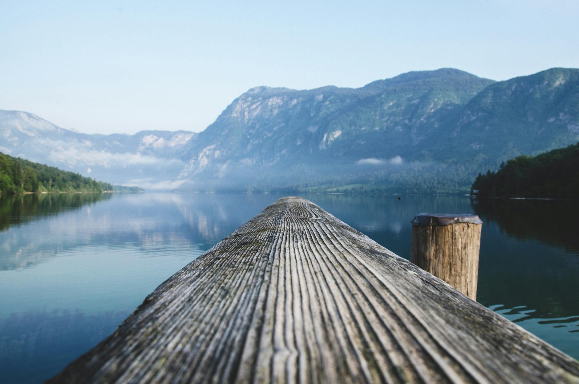 Serene view of a mountain lake from a wooden dock in Radovljica, Slovenia. - how much water spring