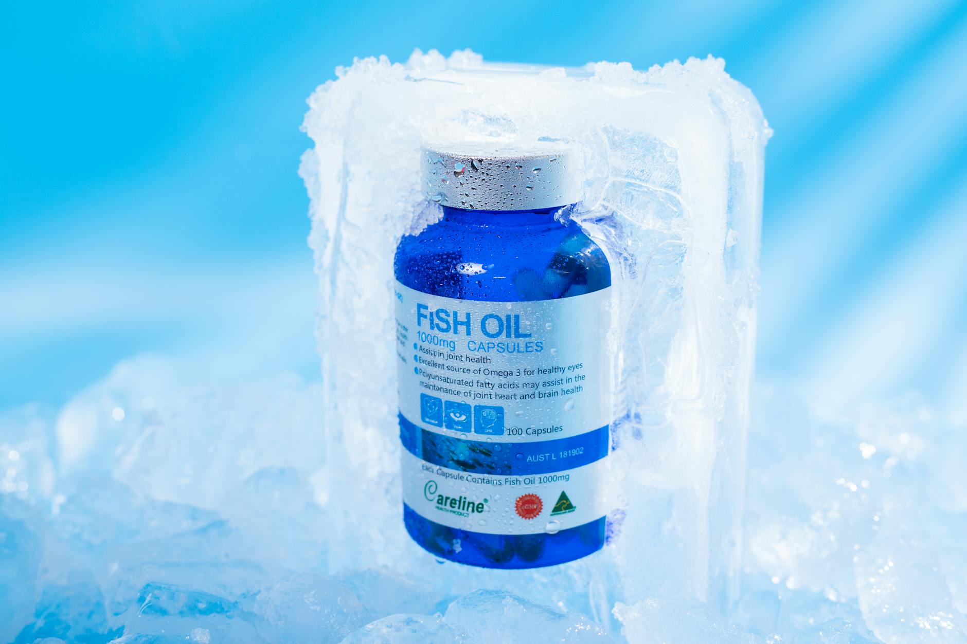 Close-up of frozen fish oil capsules in a blue bottle, highlighting purity and health benefits. - natural health products