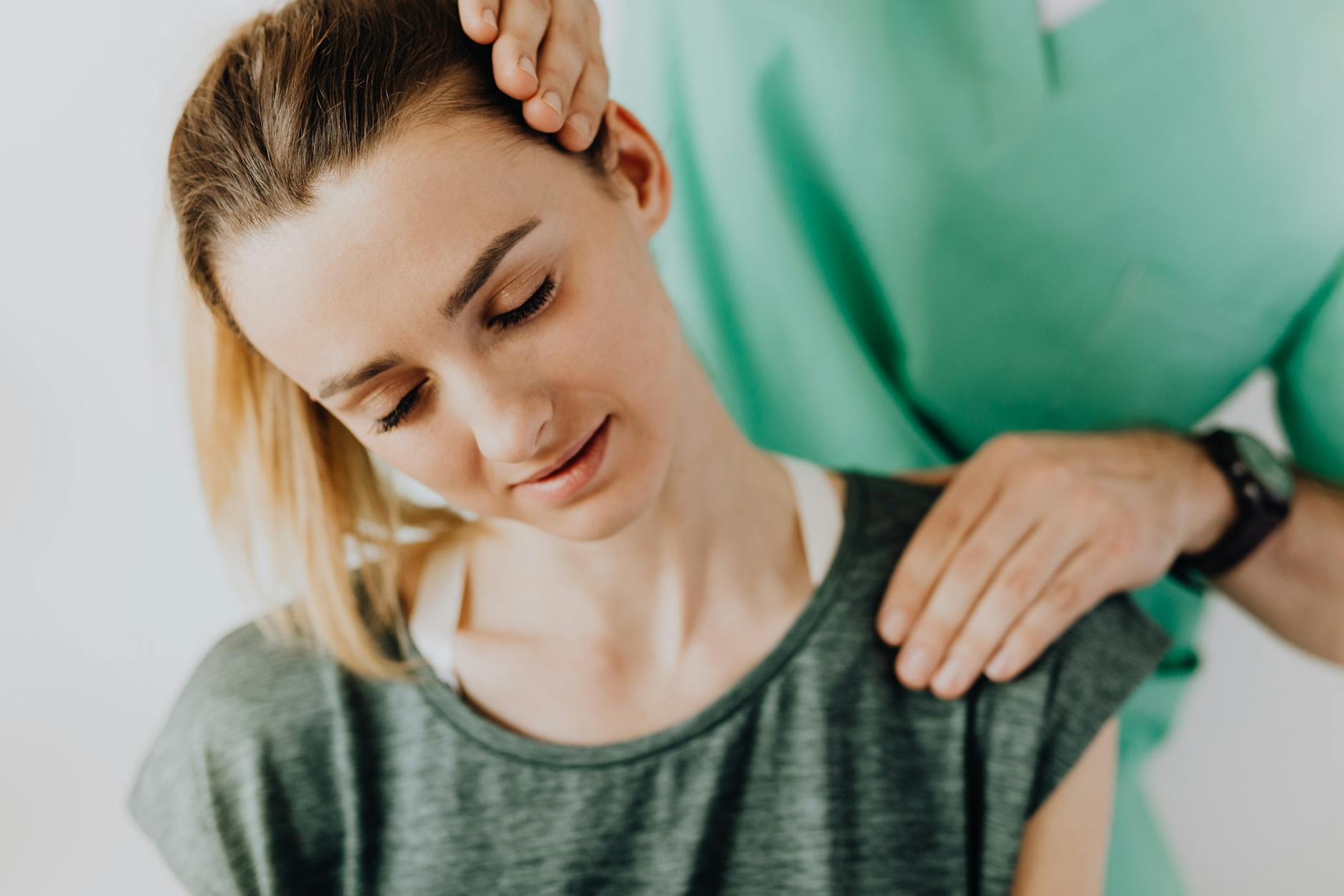 Crop professional male massage therapist in green medical uniform doing therapeutic neck massage on content female patient wearing casual clothes - neck posture exercises