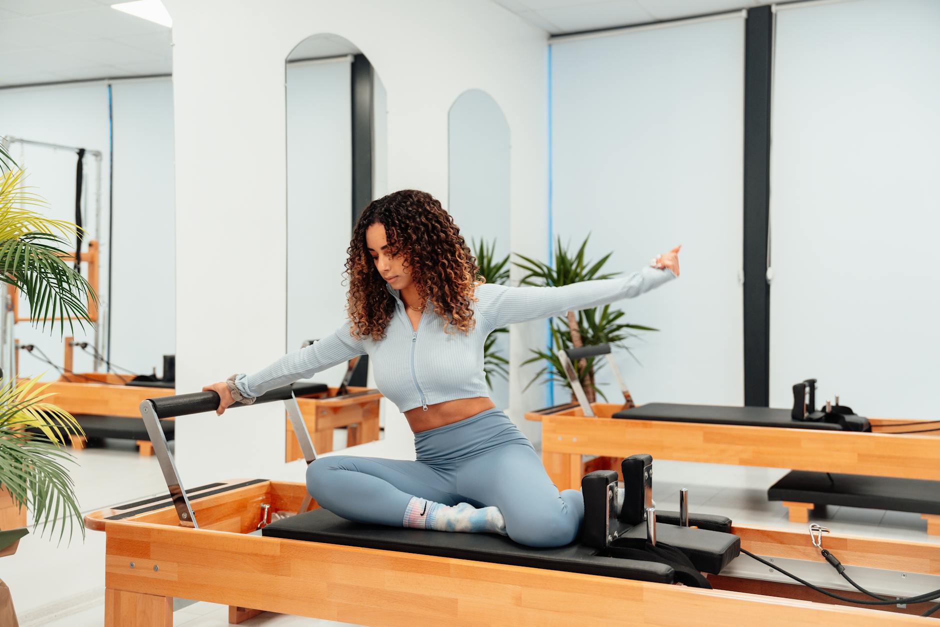 A woman exercising on a reformer in a pilates studio, embodying a healthy lifestyle. - what is pilates