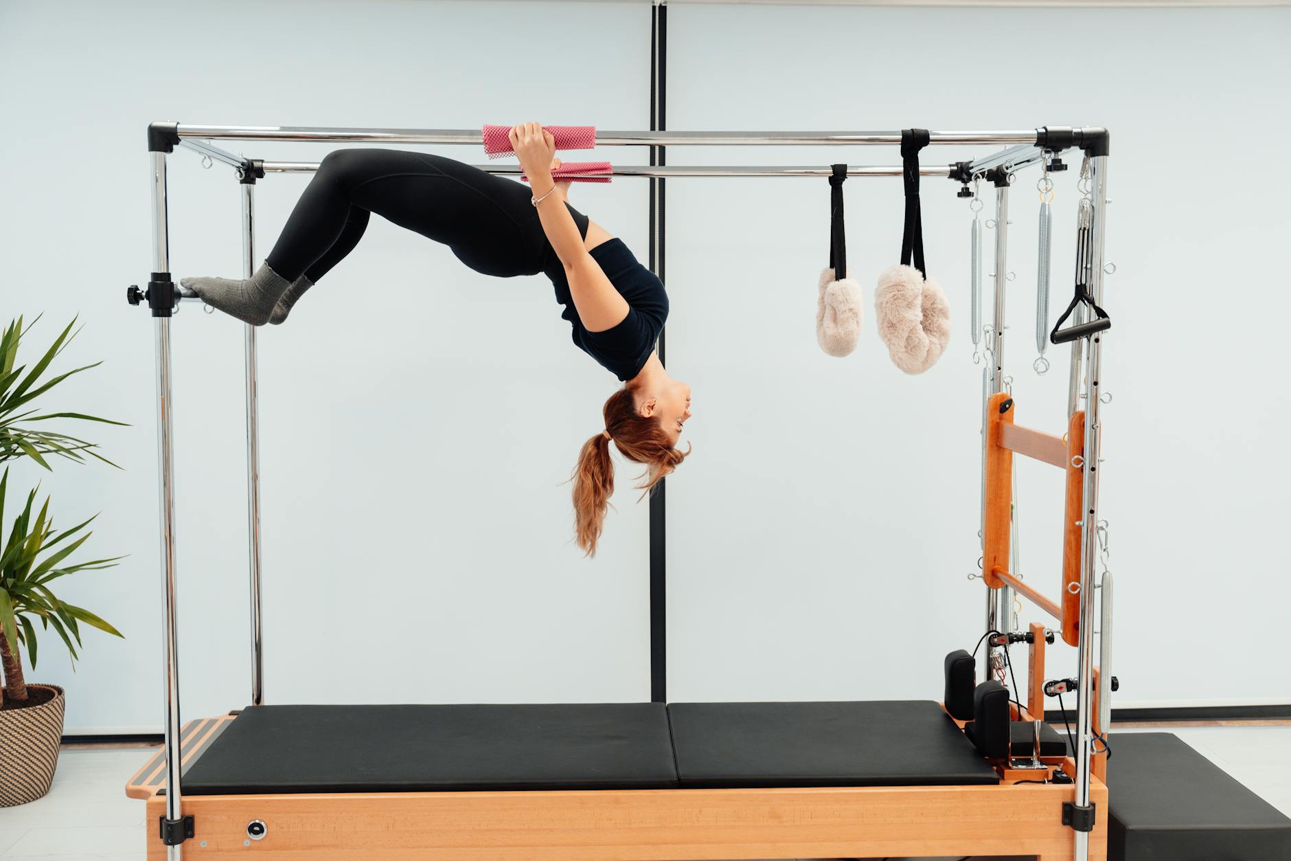 A woman engaging in a Pilates routine on a Reformer machine, showcasing strength and flexibility. - pilates reformer exercises