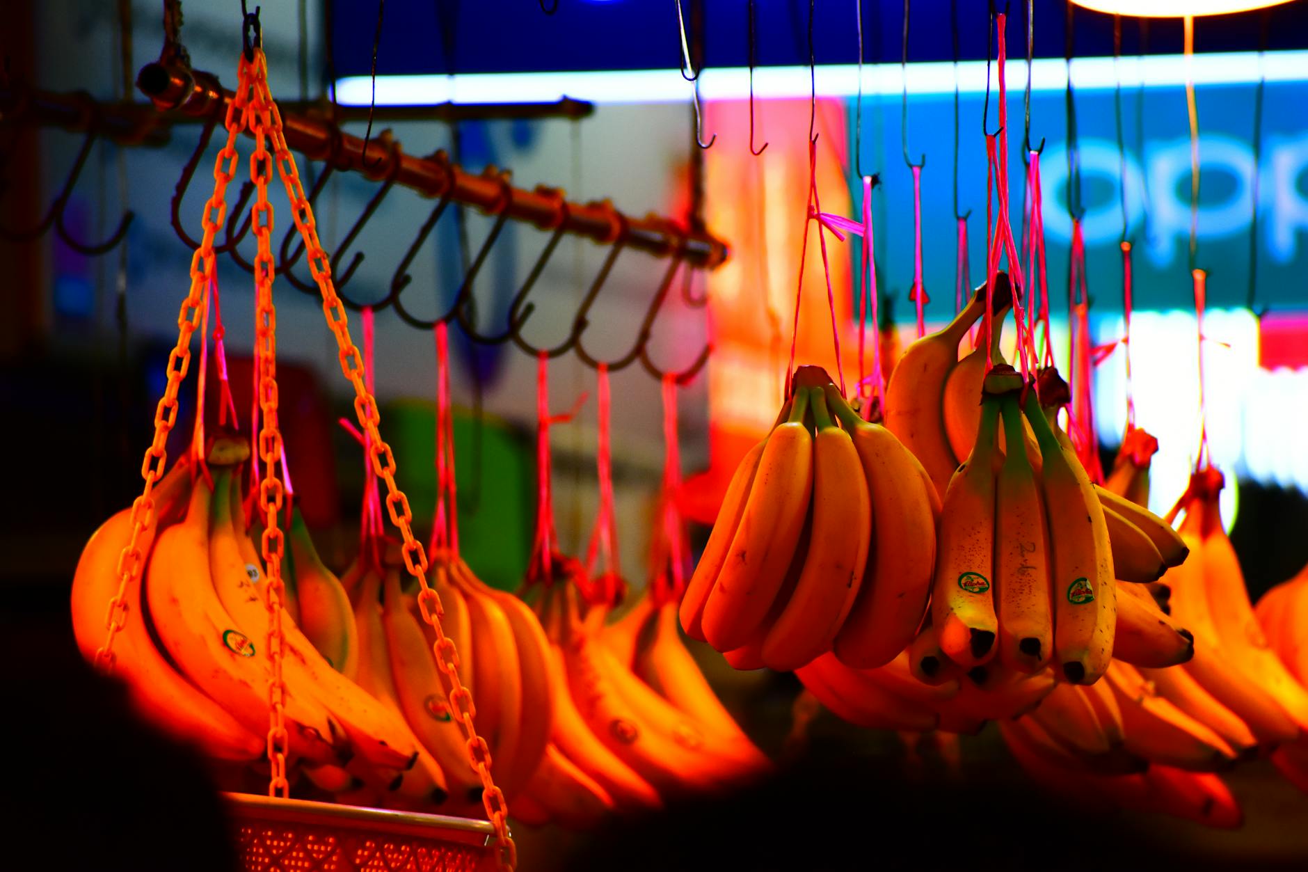 Clusters of ripe bananas hang attractively at a busy tropical market. - potassium rich foods