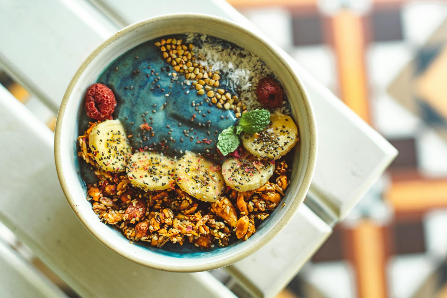 Vibrant blue spirulina smoothie bowl topped with bananas, granola, and berries for a nutritious meal. - probiotic foods boost