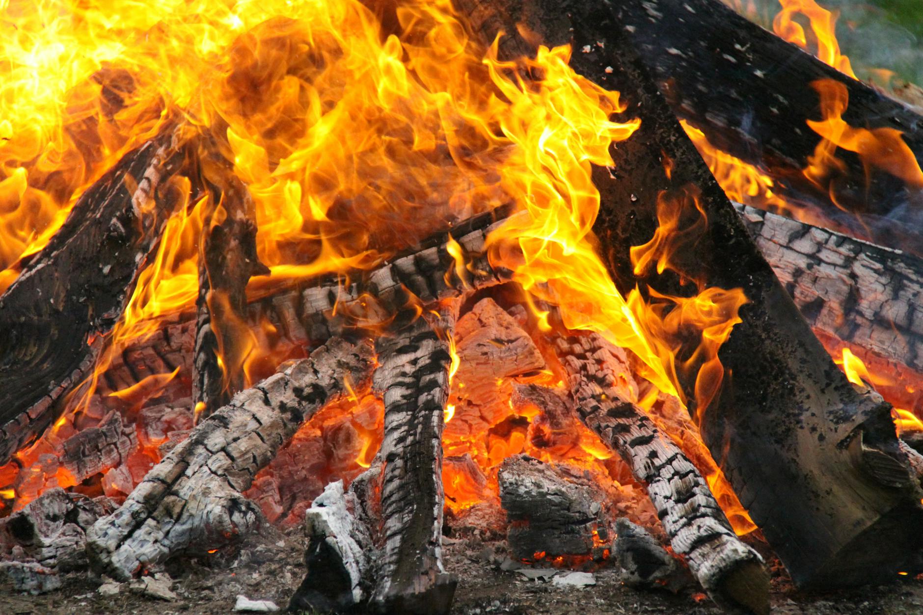 A mesmerizing close-up of a blazing bonfire with vivid flames and embers creating warmth and light. - spring fat burning