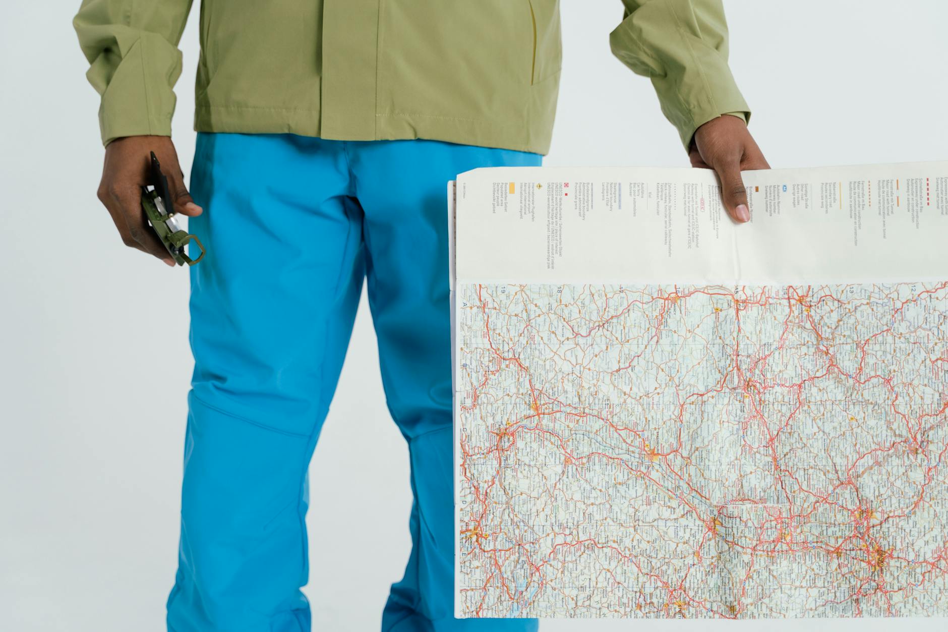 Man in outdoor attire holding a map and compass, prepared for exploration. - spring hiking guide
