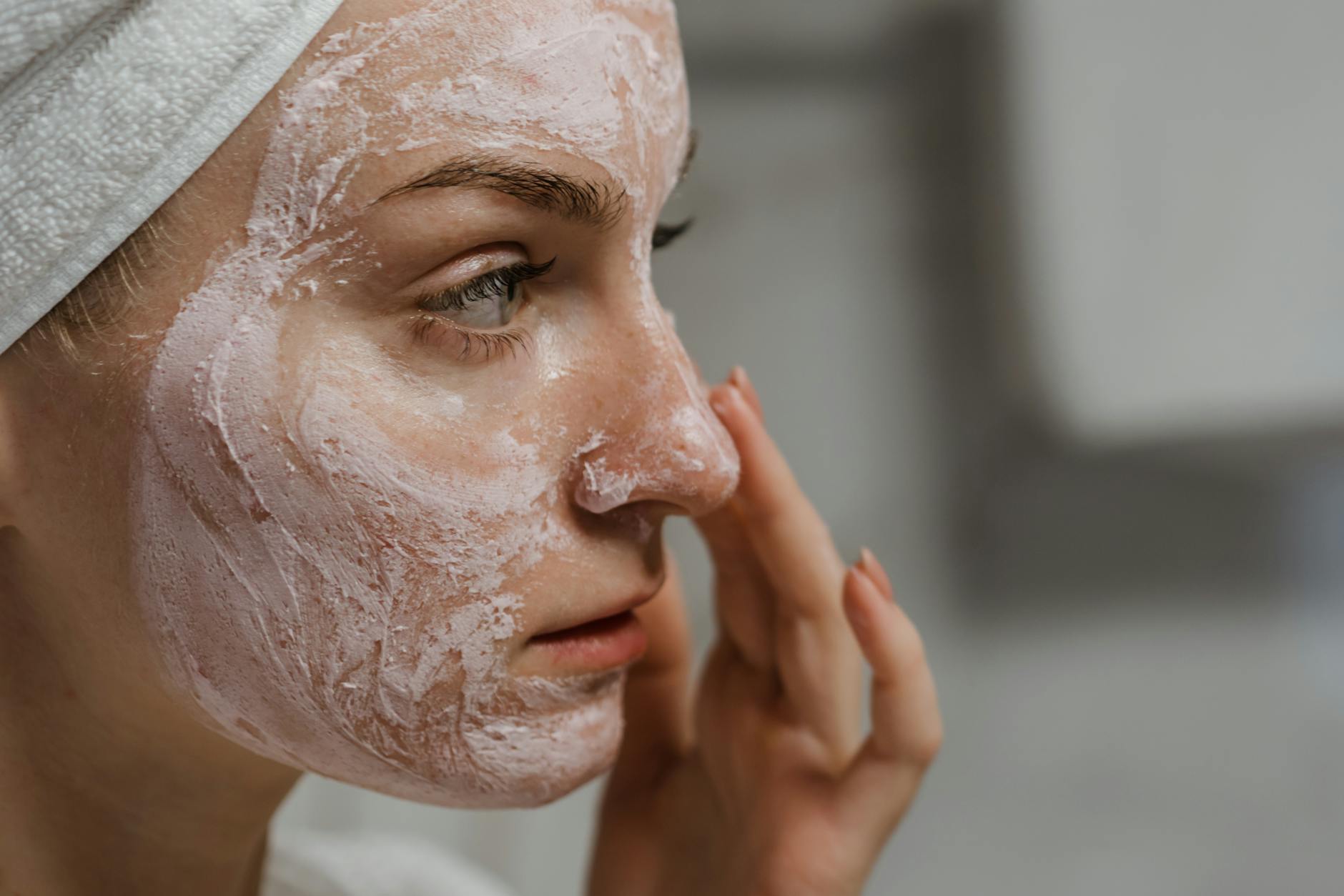 Close-up of a woman applying facial cream as part of her skincare routine, enhancing skin health. - spring skin care