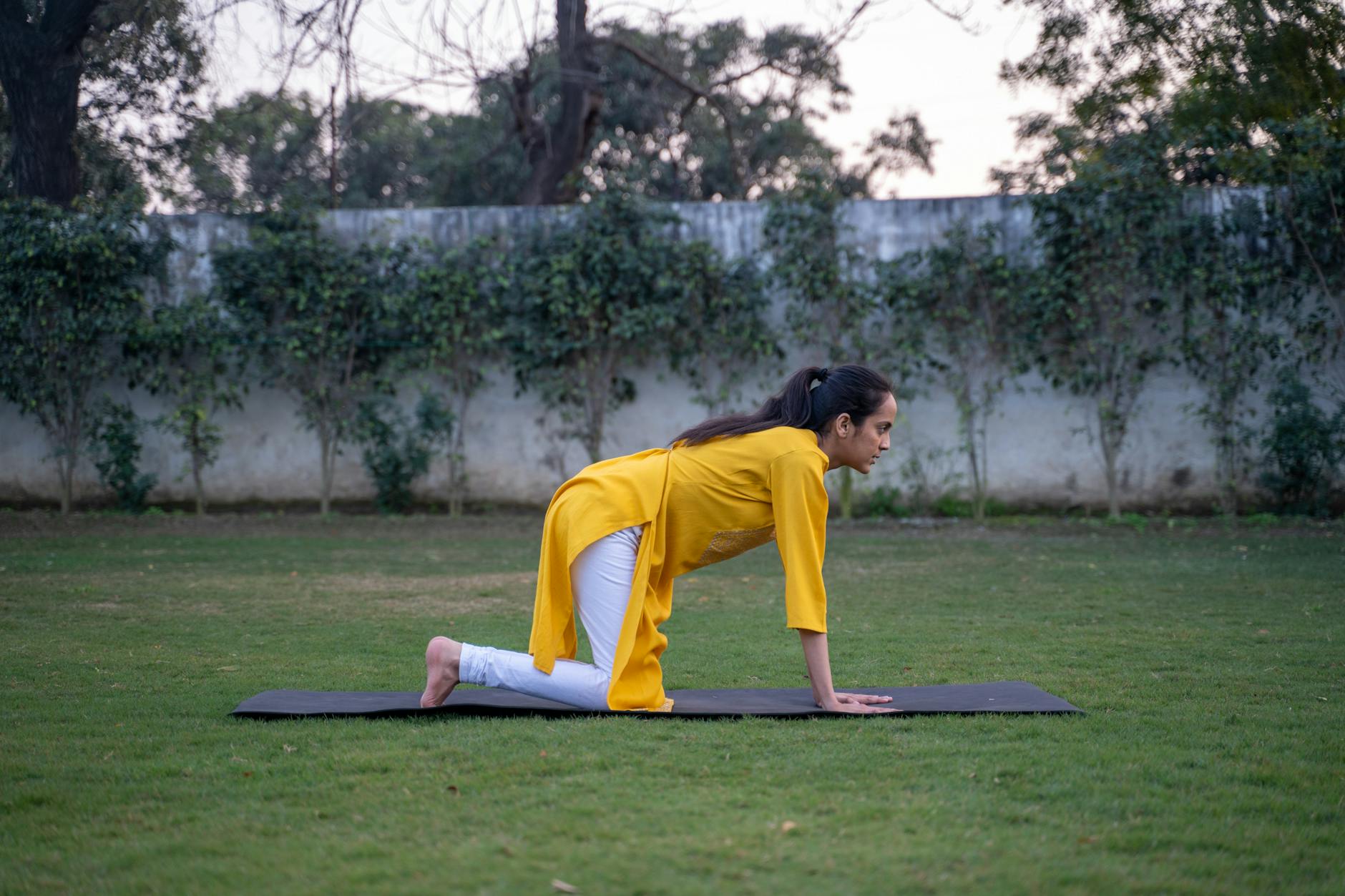 Young woman in yoga pose outdoors on a mat, promoting wellness and healthy living. - spring yoga poses