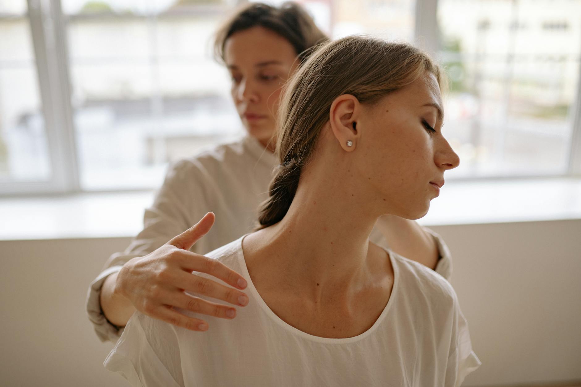 Two women engaged in a calming massage session, promoting wellness and relaxation. - stress management techniques