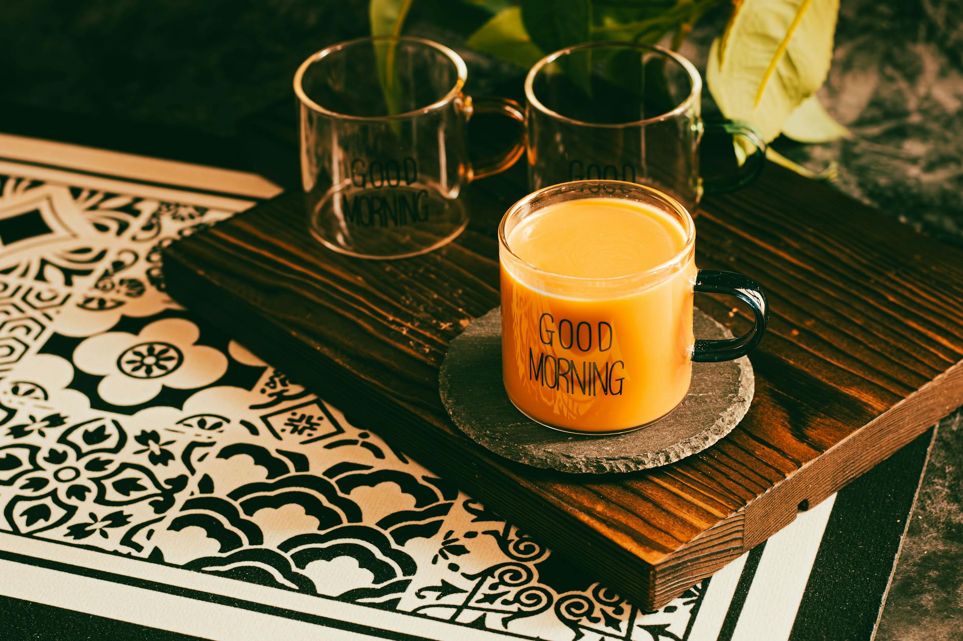 A warm mug of coffee with 'Good Morning' text on a decorative table setting. - sunlight mood boost