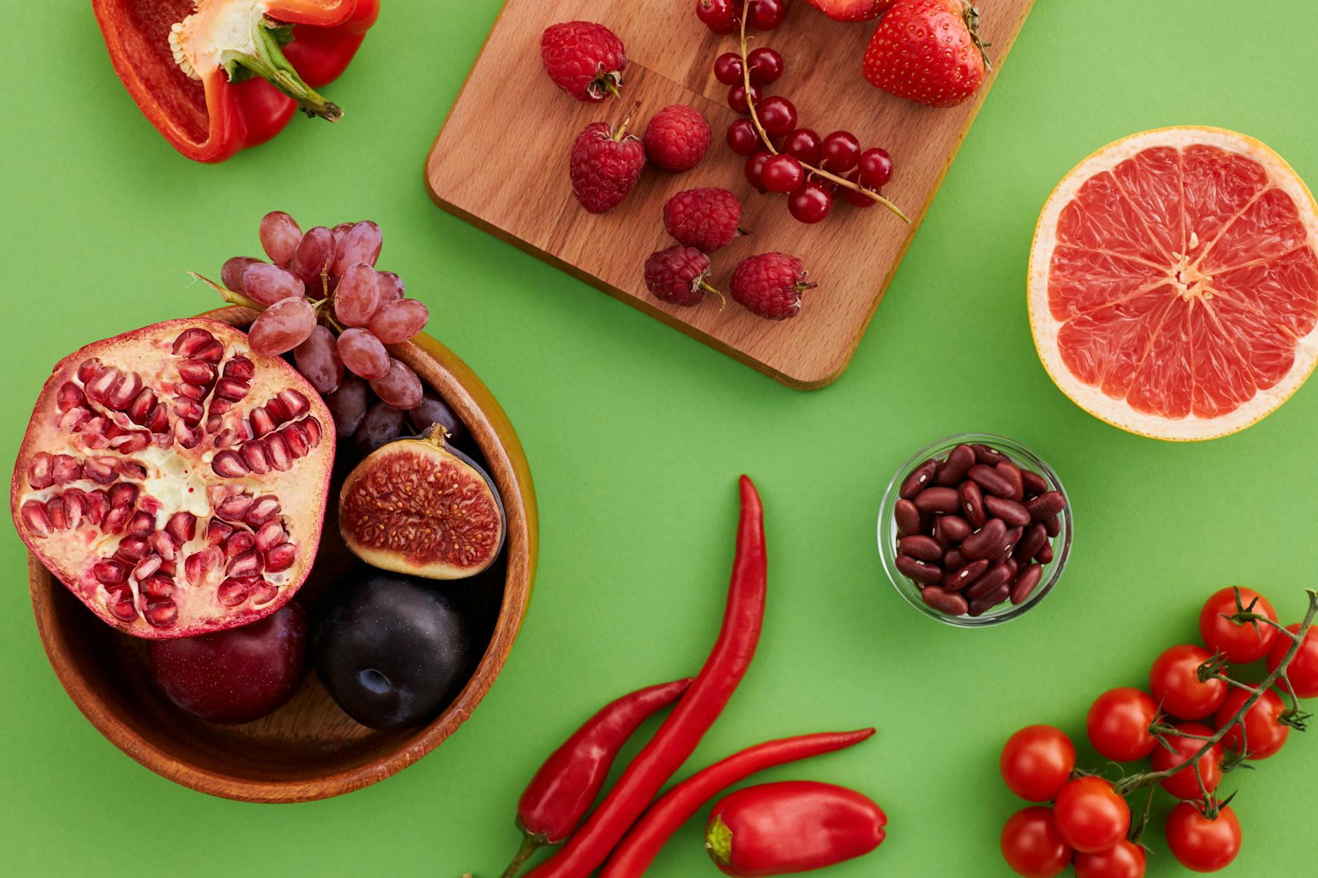 A vibrant display of fresh fruits and vegetables on a green surface. - anti-inflammatory foods