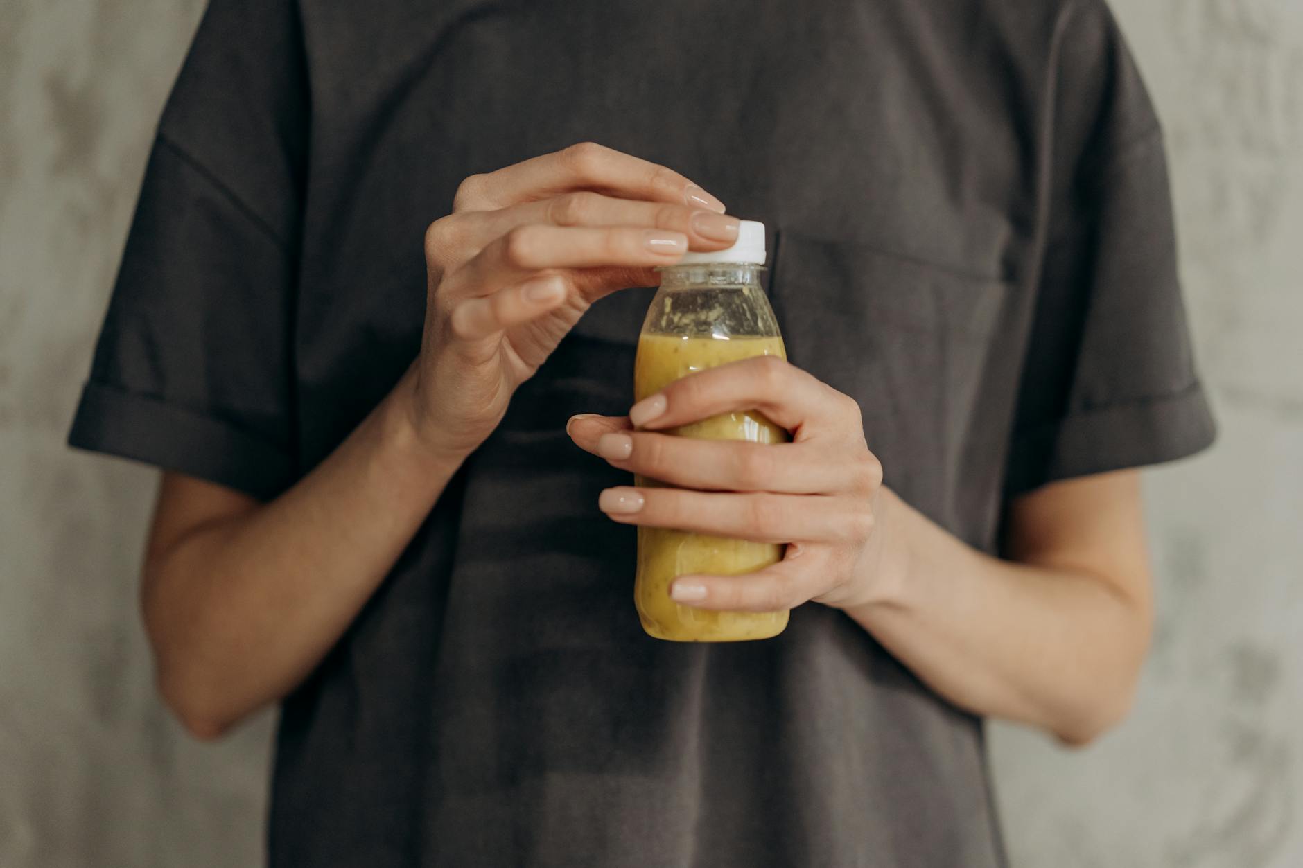 Close-up of a woman holding a bottle of fresh juice, symbolizing a healthy lifestyle. - body detox diet