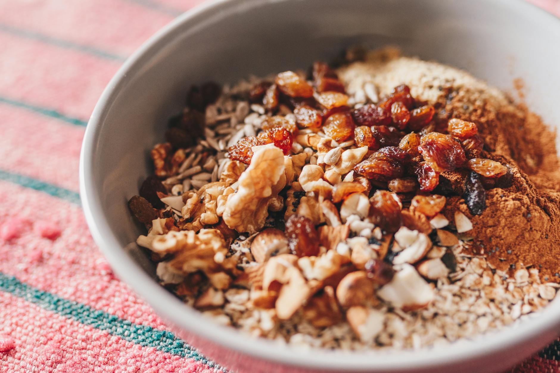 A nutritious oatmeal bowl topped with walnuts, sunflower seeds, and raisins. - boost metabolism foods