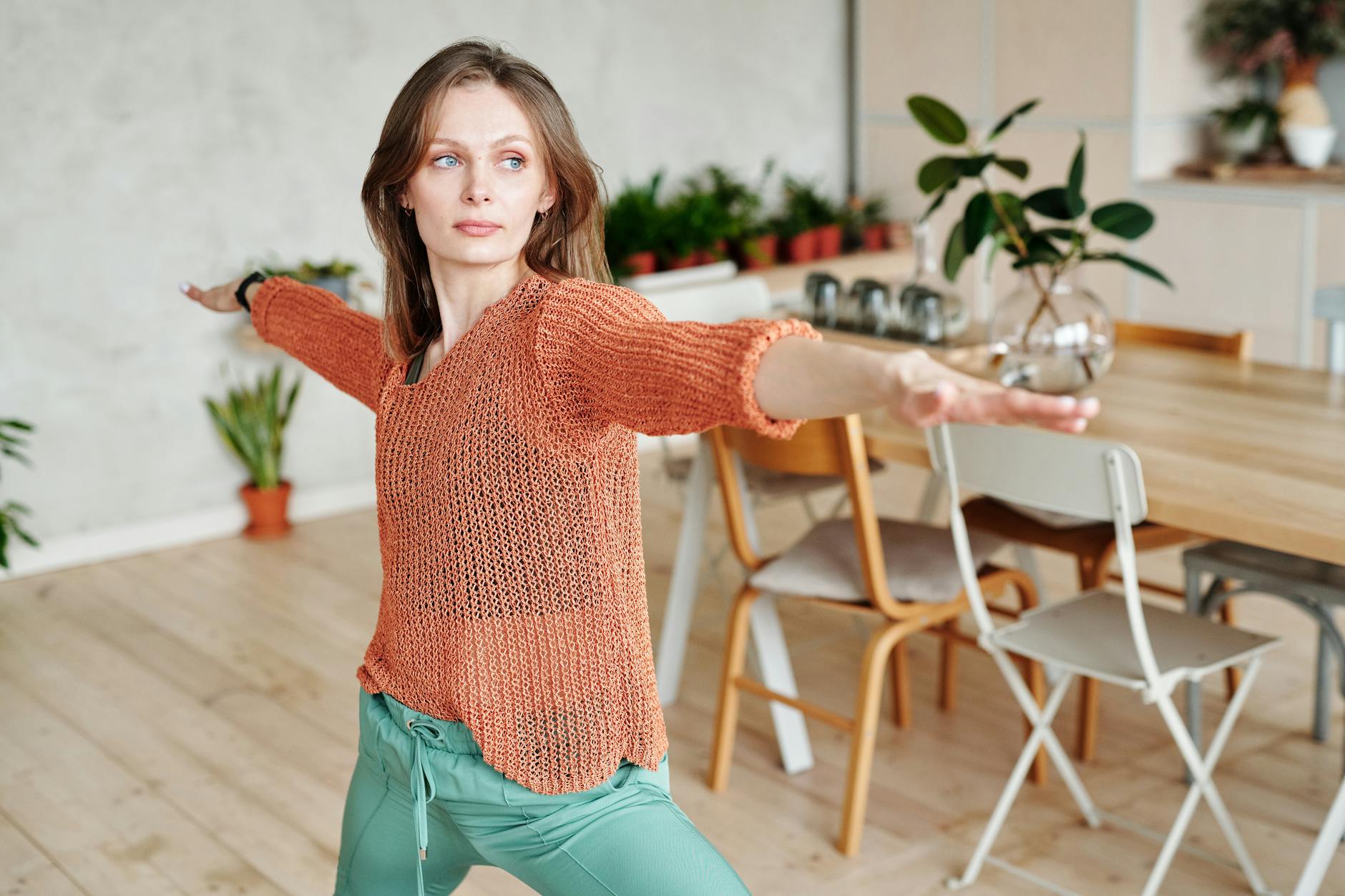 A woman performs a yoga pose indoors, showcasing balance and serenity. - chair yoga poses