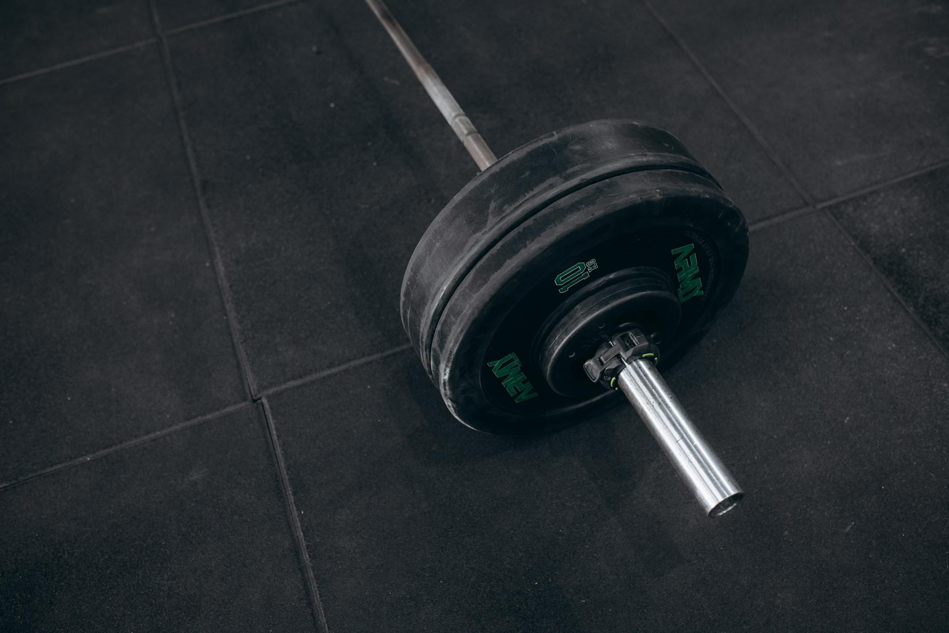 Heavy barbell resting on a gym floor, ideal for strength training visualizations. - gardening strength training