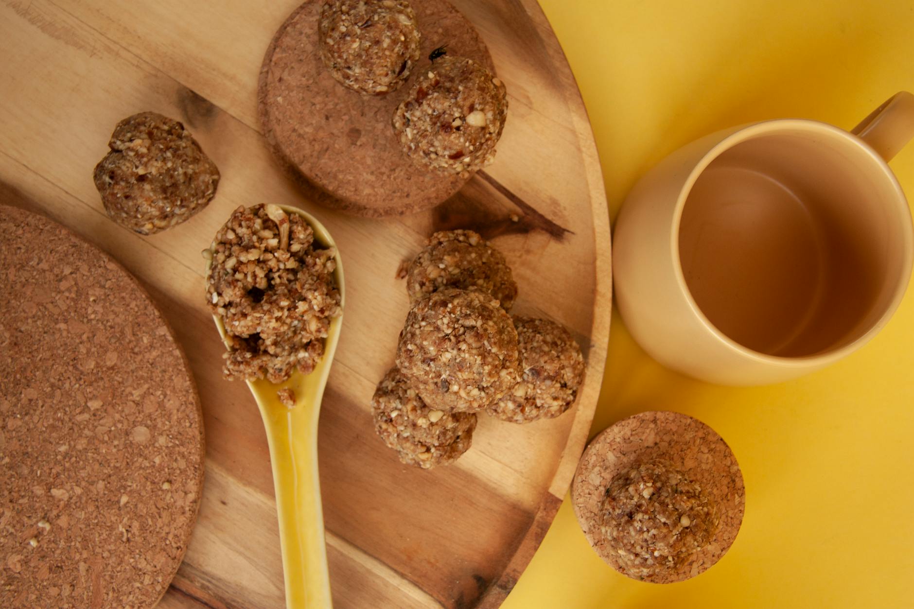 Flat lay of homemade energy balls with tea cup on a wooden tray, perfect for a healthy snack. - healthy snack recipes