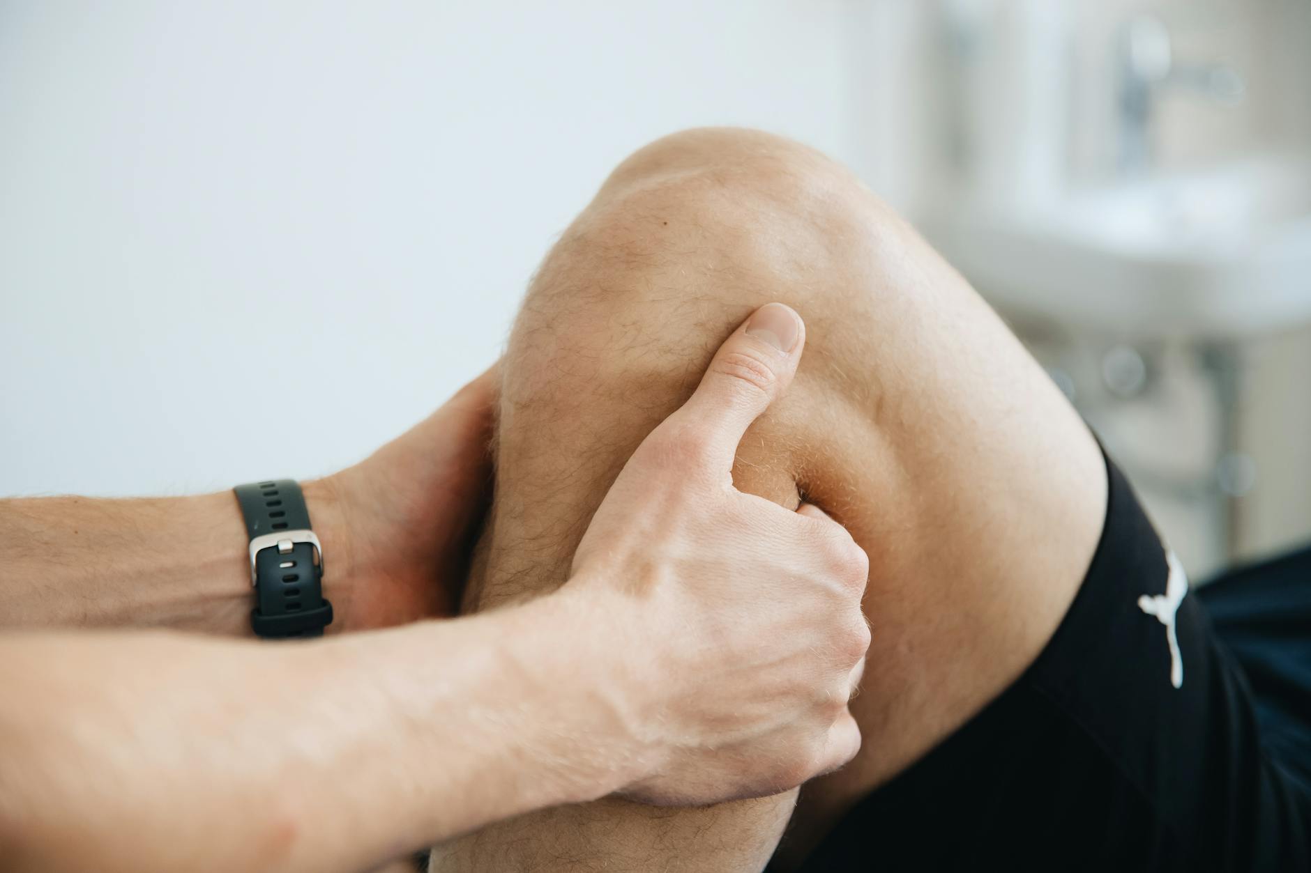 Close-up of a physiotherapist massaging a patient's knee during therapy. - knee pain relief exercises