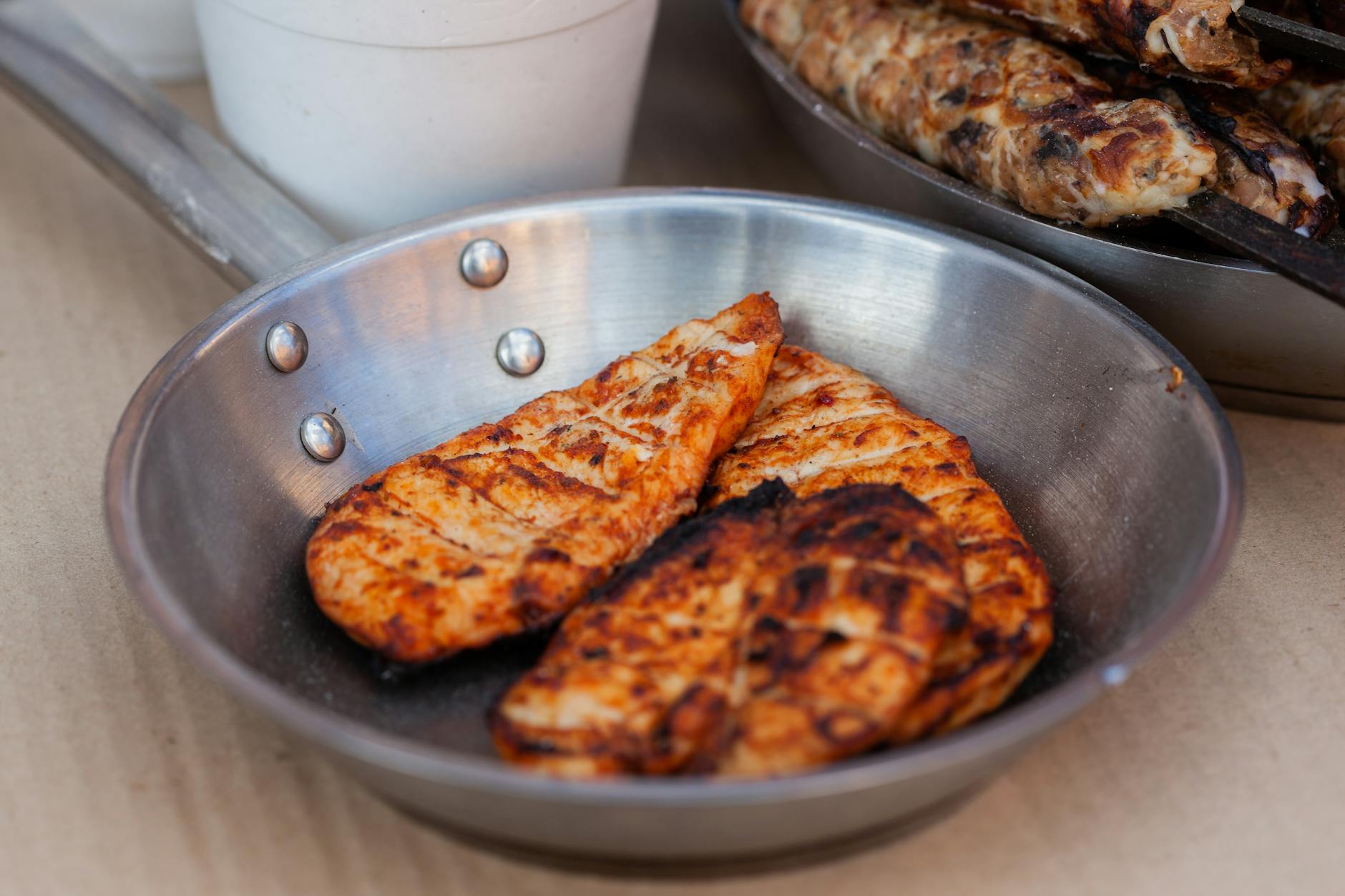Delicious seasoned chicken breasts grilled and served in a stainless steel pan. - low carb chicken