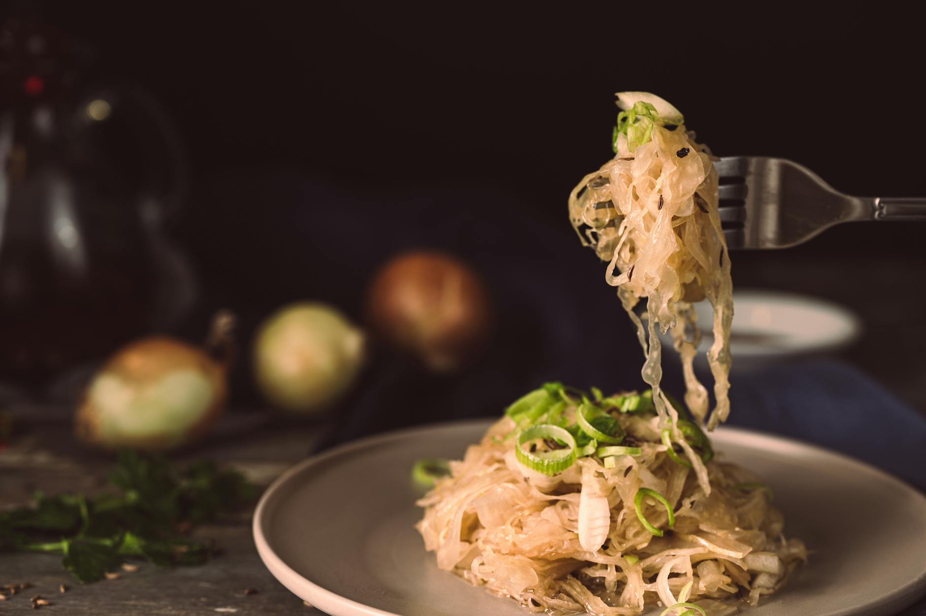 A mouthwatering plate of sauerkraut garnished with green onions, ready to eat. - probiotic recipes