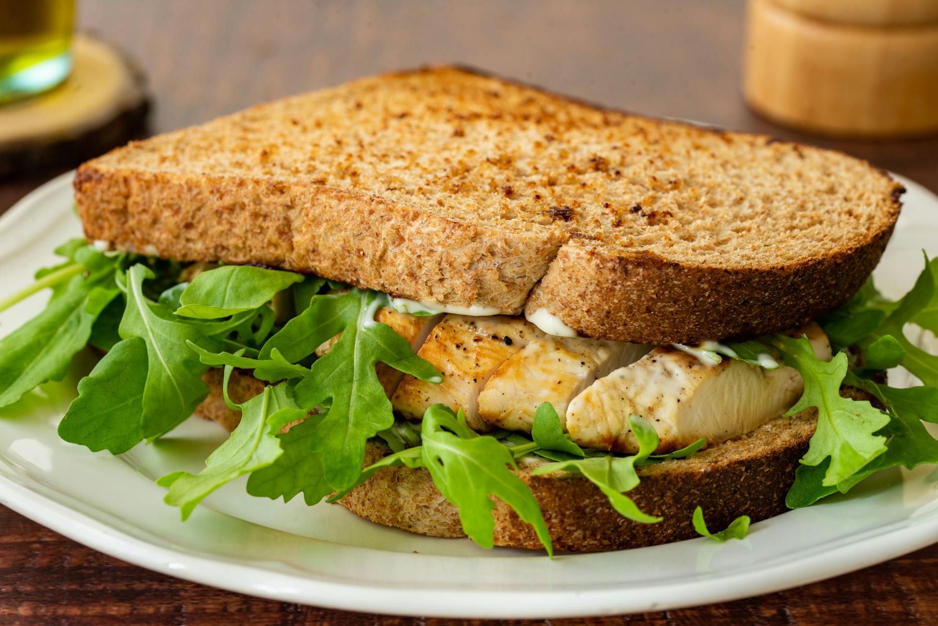 A tasty grilled chicken sandwich on toasted whole wheat bread with mayonnaise and fresh arugula. - quick lunch recipes