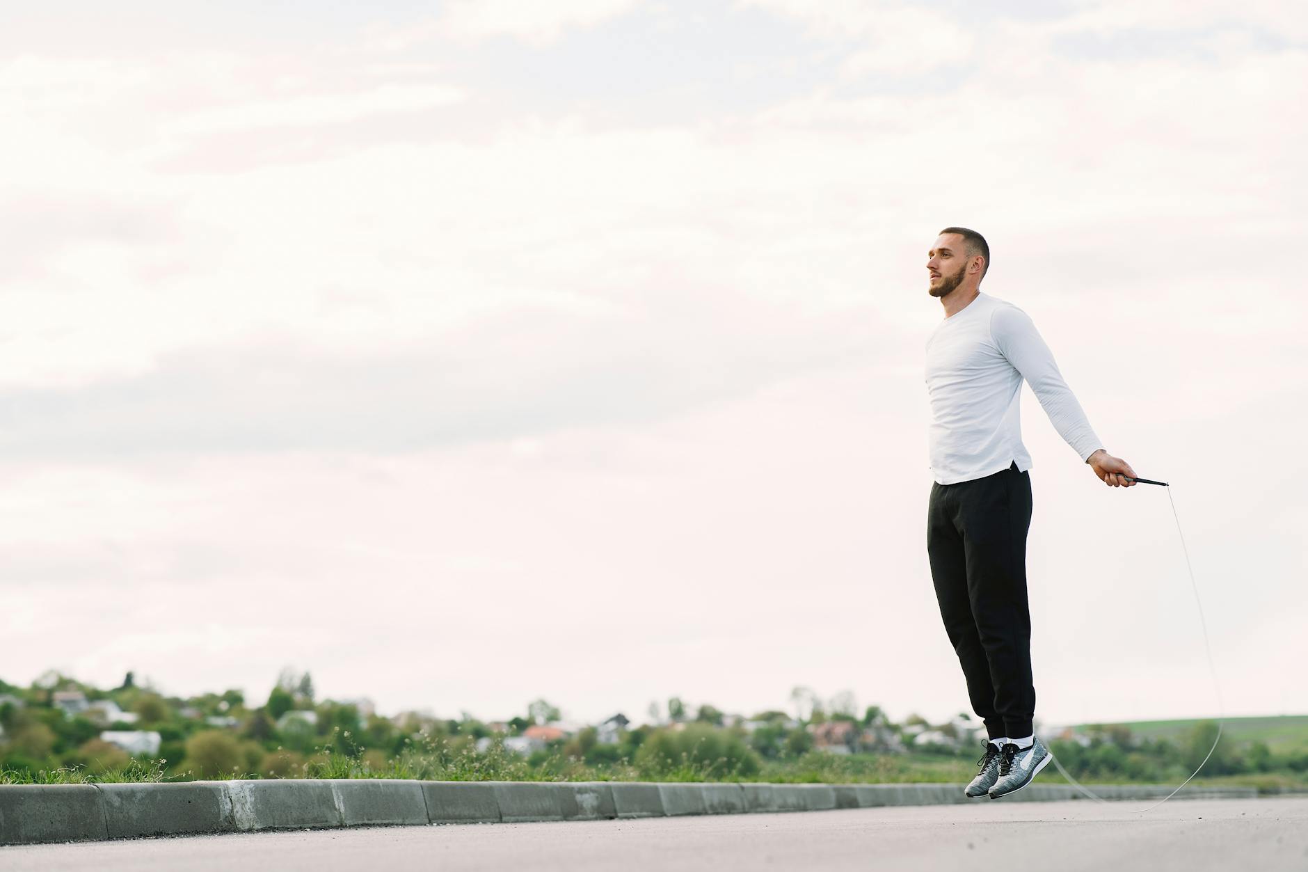 Man performing jump rope exercise outdoors for fitness and healthy lifestyle. - spring cardio fat burn