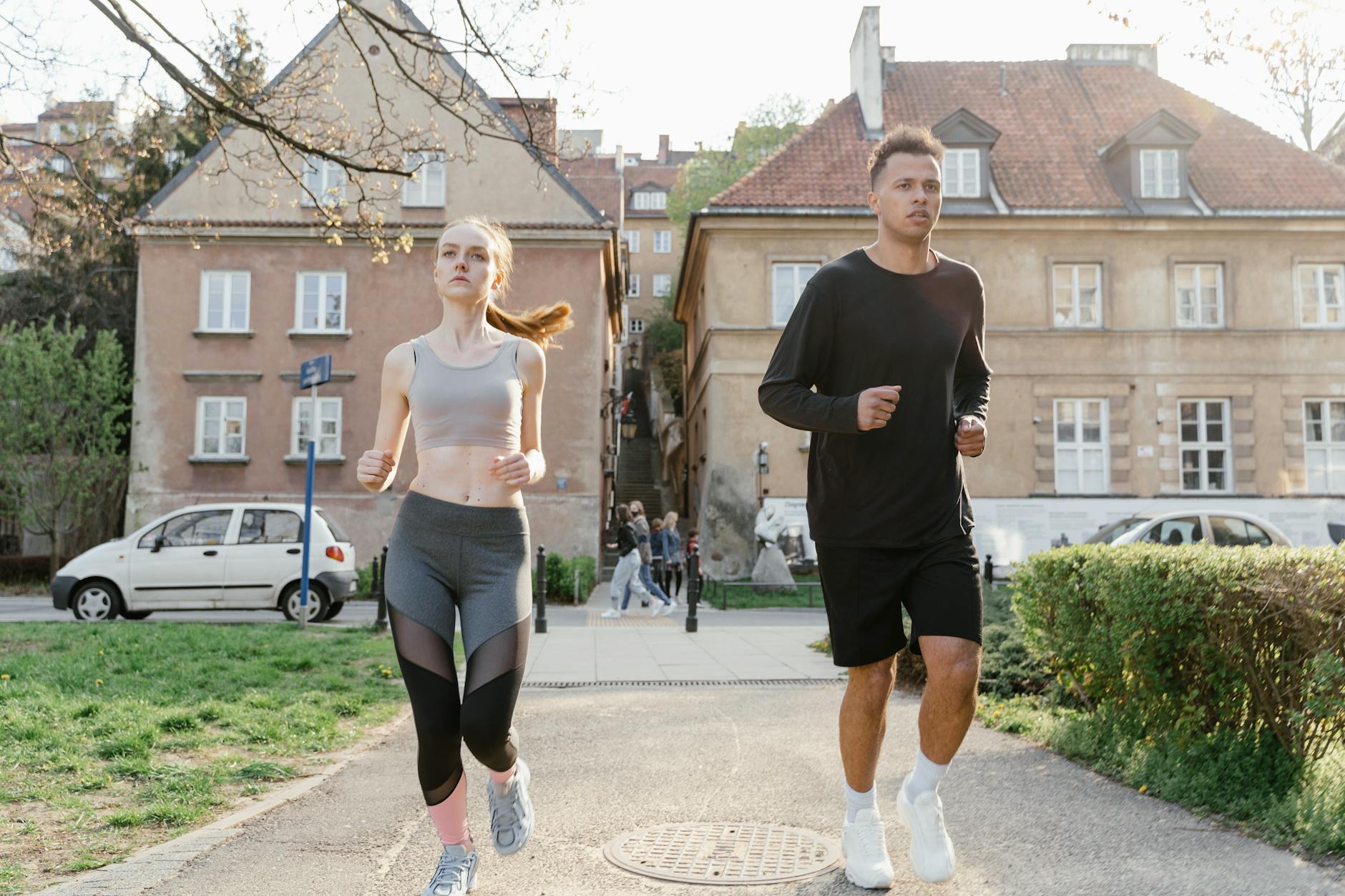 Two young adults jogging on a city path, showcasing an active lifestyle in an urban environment. - spring fitness goals