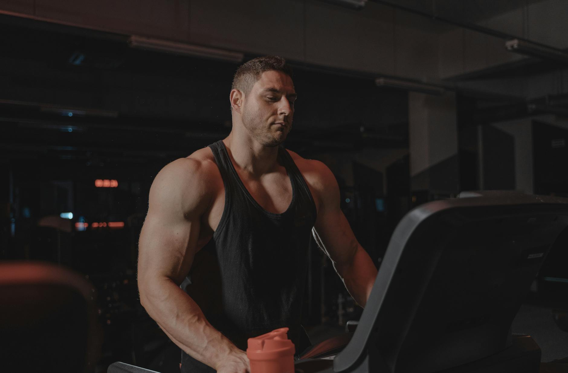 A bodybuilder working out on a treadmill at the gym, focused on fitness and strength training. - best gold standard pre workout