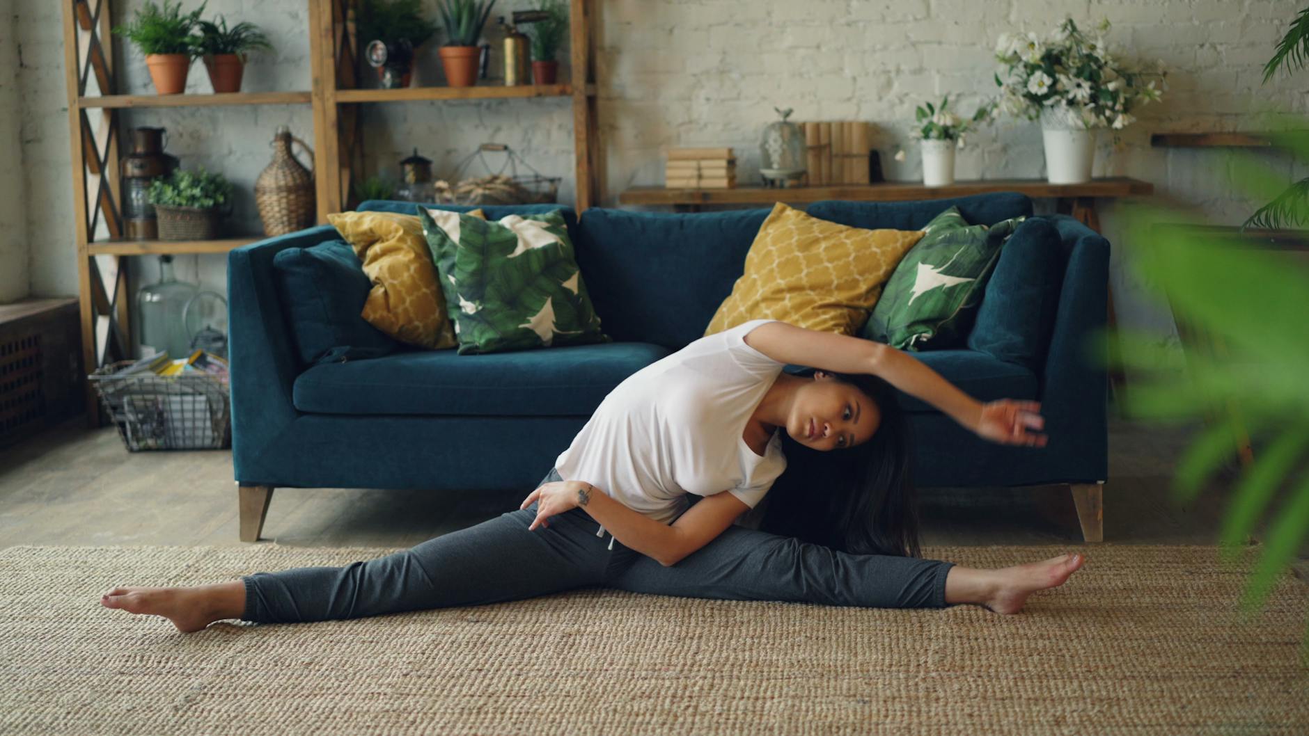 Woman practicing yoga indoors, performing side stretch on floor. Cozy and serene home environment. - desk stretches