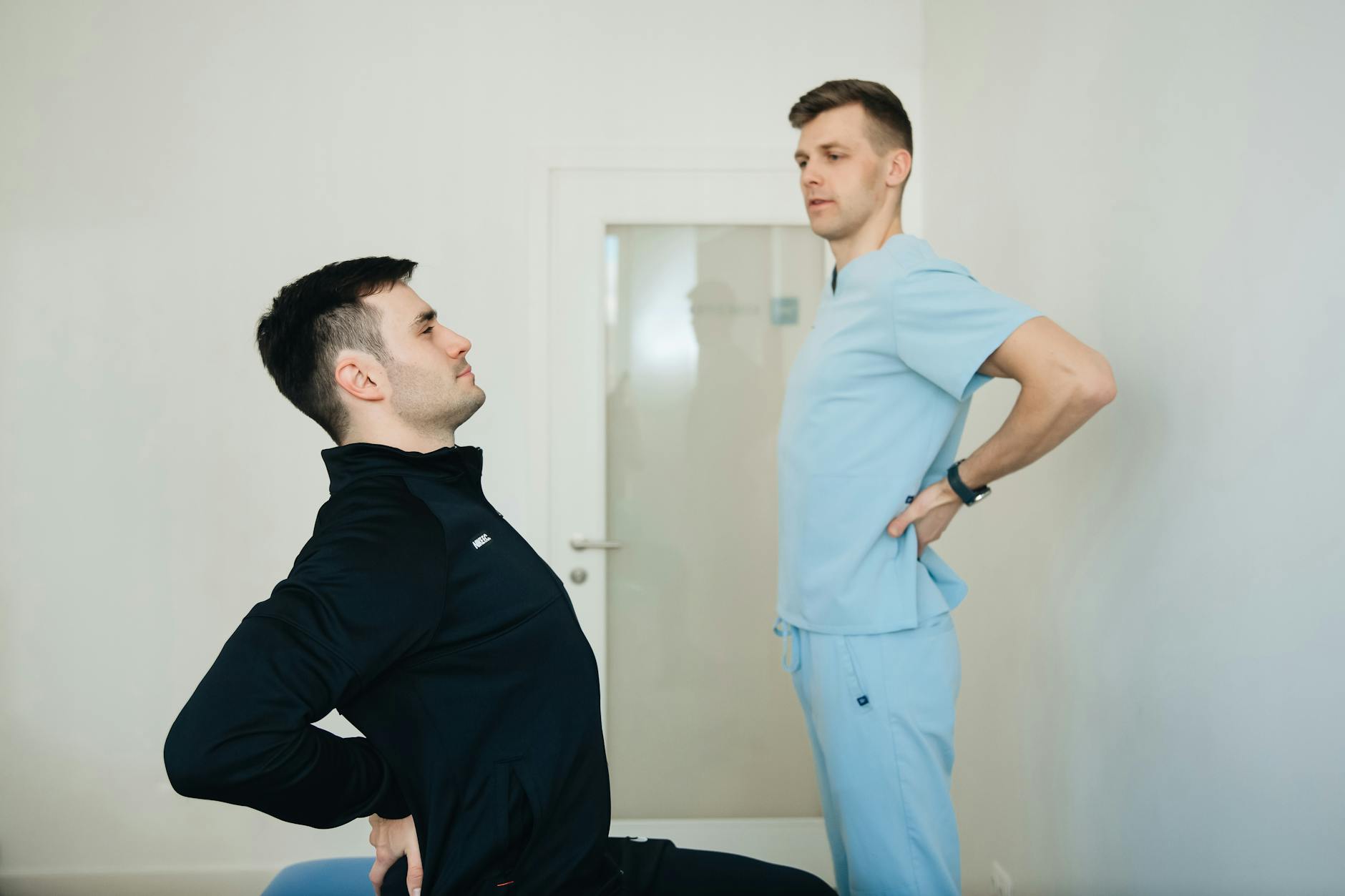A physiotherapist instructs a patient on back exercises in a clinic setting. - improve posture