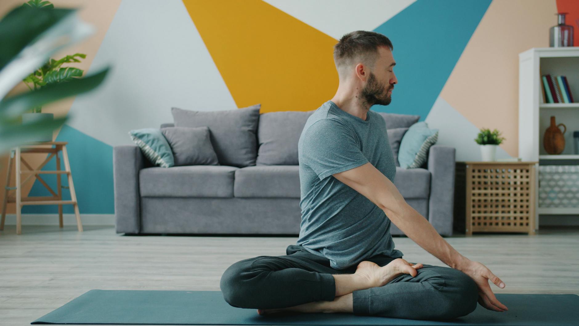 Man doing yoga in a stylish living room. Practicing mindfulness and relaxation. - improve posture