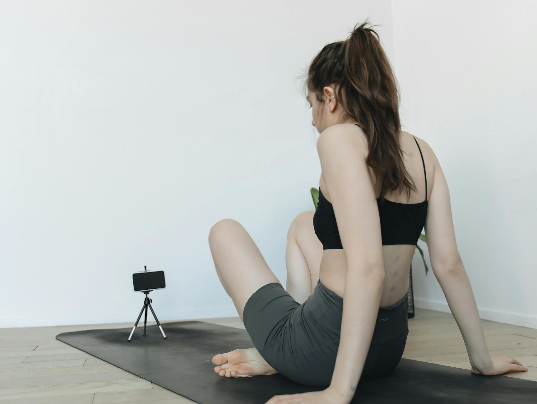 Woman doing yoga exercises at home, recorded on smartphone tripod for blogging content. - improve posture