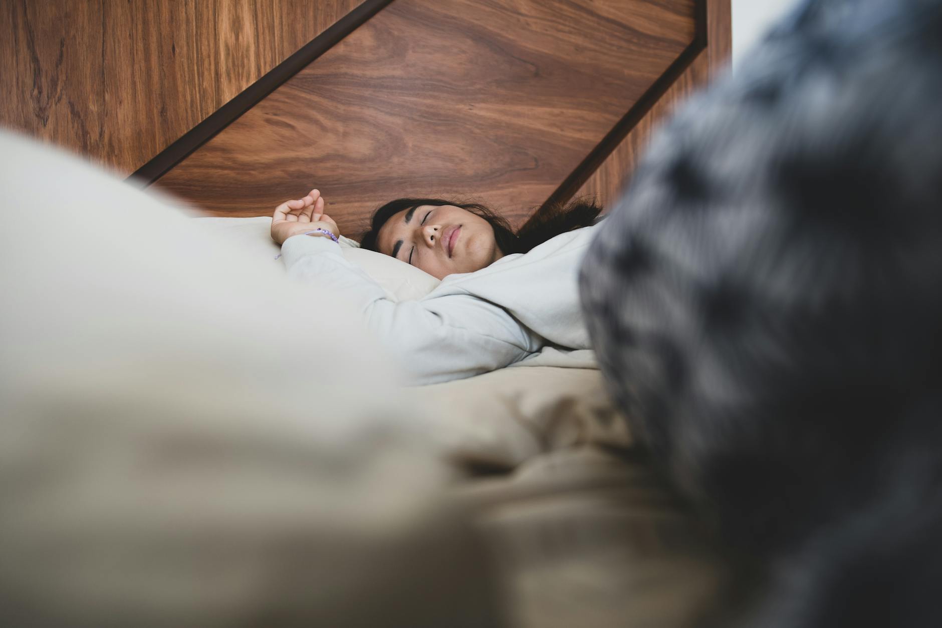 A woman peacefully sleeping on a bed, conveying relaxation and comfort. - magnesium for sleep