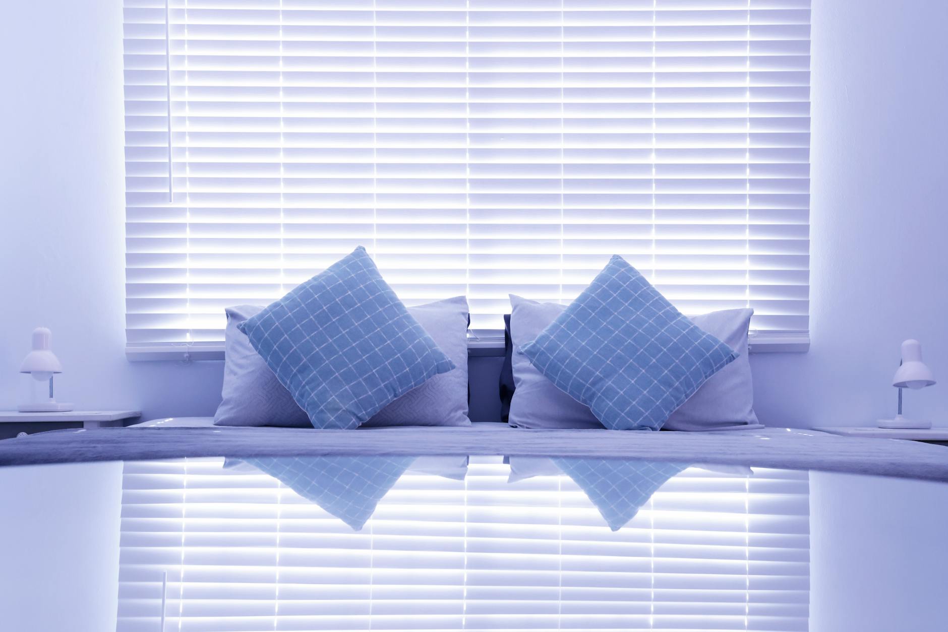 Stylish and modern bedroom with blue cushions and blinds, reflecting a calm and cozy atmosphere. - restful bedroom environment