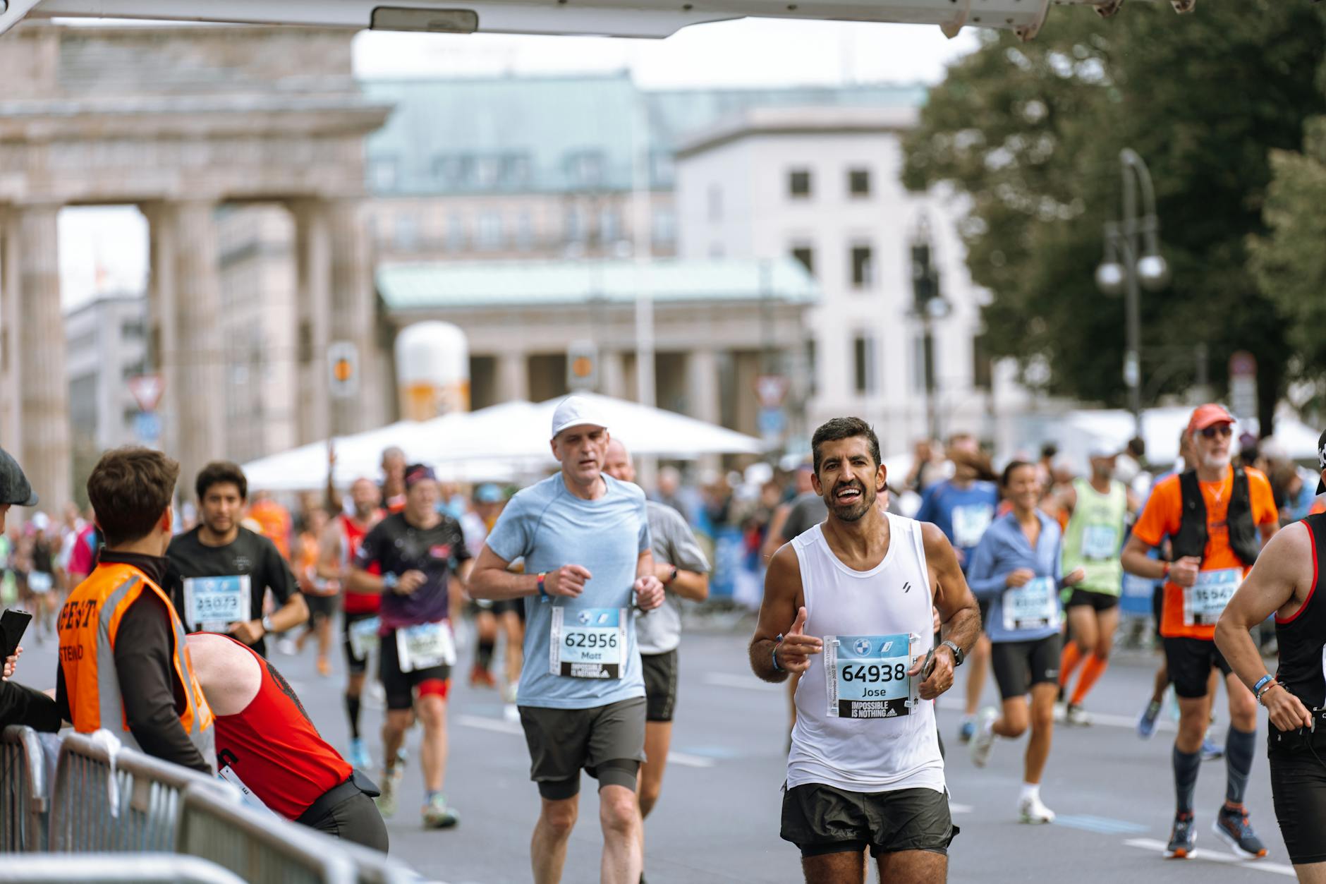 Runners cross finish line at Berlin Marathon, showcasing athletic determination. - spring marathon training